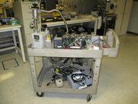 Various Lab Equipment on Cart including Leybold D8A Trivac Rotary Vane Pump, Leybold NT-10 Turbo Pump Controller, MKS Instruments Series 999 Quattro Multi-Sensor Transducer, Aidxen Vacuum Pump, Clamps and Exam Gloves, Cart.s/n Tag #N/A Category: Lab Locat