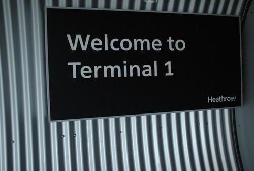 Wall mounted 'Welcome to Terminal 1' sign, metal box construction with curved profile back.