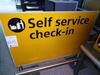 Self service check-in' sign