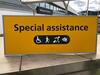 Wall mounted metal sign, showing 'Special assistance' message.