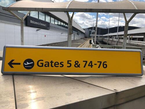 Wall mounted sign, curved metal surround, showing Gates 5 & 74-76