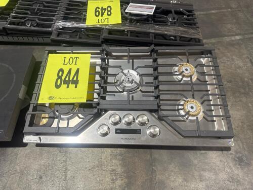 Monogram ZGU36ESL1SS 36" Built-In Gas Cooktop featuring 5 burners, including a 20,000 BTU tri-ring burner, sapphire glass precision knobs with illumination, electronic kitchen timer, brass burner accents, continuous cast iron grates, and stainless steel f
