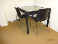 Metalen tafel met glazen blad en twee stoelen (Metal framed table with glass top and 2 chairs.)