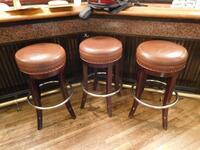 (4) LB ROUND BROWN LEATHER STOOLS (31" TALL X 16" DIAMETER) - (LOCATION: MAIN 1ST FLOOR BAR NEAR ENTRANCE)