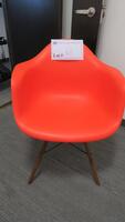 HERMAN MILLER "EAMES" MOLDED PLASTIC ARMCHAIR, WALNUT FINISH WOOD DOWEL BASE, RED ORANGE SEAT AND BACK. MSRP $666