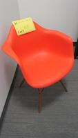 HERMAN MILLER "EAMES" MOLDED PLASTIC ARMCHAIR, WALNUT FINISH WOOD DOWEL BASE, RED ORANGE SEAT AND BACK. MSRP $666