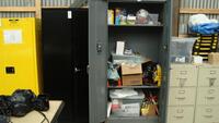 Grey storage cabinet with contents (gloves, wipes, safety equipment, tyvec suites)