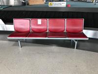 Four person seat, red leather style front and backs, cast alloy construction, no arms.