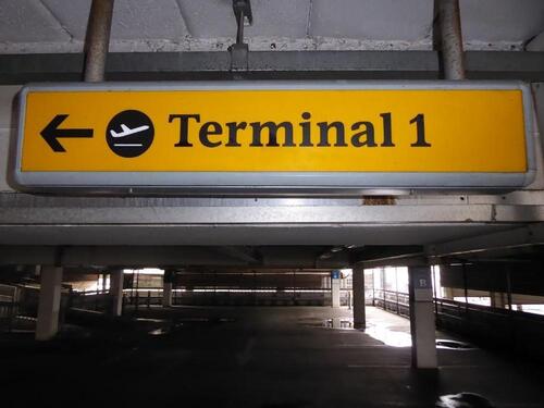 Terminal 1 direction sign, illuminated. Curved metal edge construction including internal light fittings.