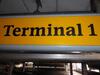 Terminal 1 direction sign, illuminated. Curved metal edge construction including internal light fittings. - 7